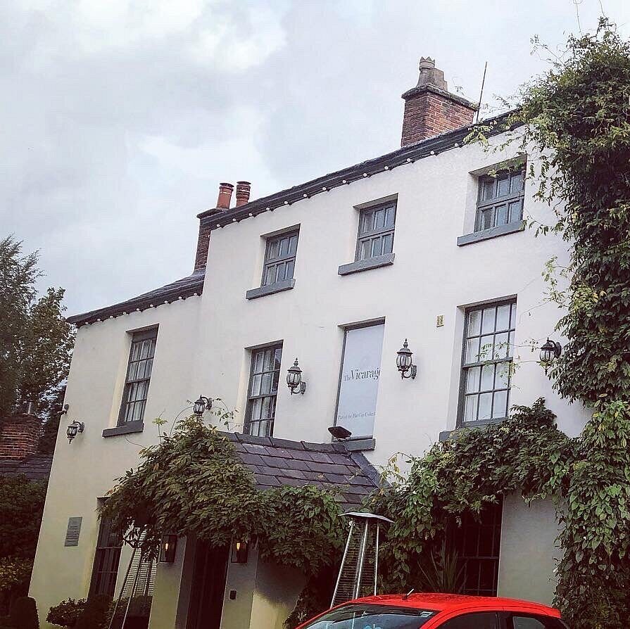 The white-painted front of The Old Vicarage, with ivy climbing around the entrance